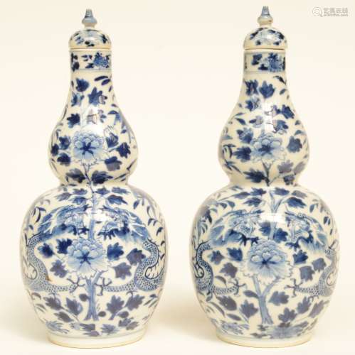 A pair of Chinese blue and white double gourd vases and covers, decorated with dragons and flower branches, marked, H 26 cm (one vase with restoration in the neck)