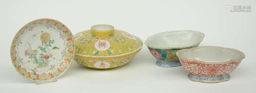 A Chinese polychrome bowl and cover, and two bowls, decorated with floral motifs and symbols, marked, 19thC; added a Chinese famille rose plate decorated with flower branches and floral motifs, marked Yongzheng, H 7 - 11 / Diameter 18 - 25 cm (plate with hairlines and chip on the rim)