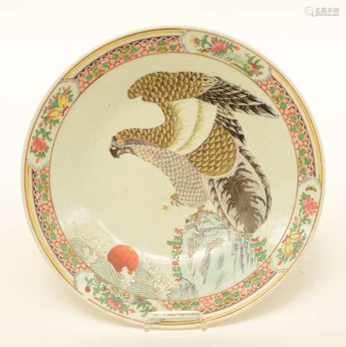 A Japanese polychrome plate, decorated with a falcon on a rock, 19thC, Diameter 35 cm