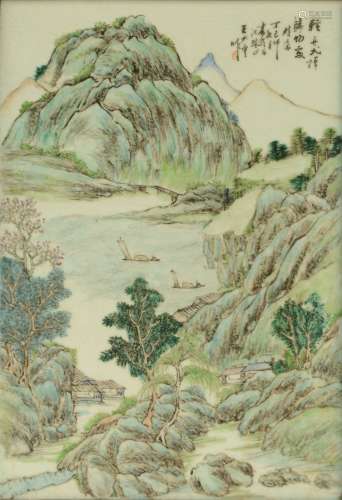 A Chinese polychrome plaque decorated with a mountanious river landscape, in a carved wooden frame, 29 x 42 cm