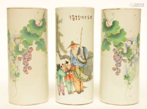 A pair of Chinese polychrome cylinder shaped vases, decorated with grape branches, marked; added a ditto vase decorated with an animated scene, marked, H 29 cm