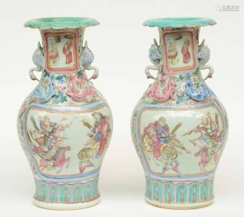 A pair of Chinese famille rose vases, decorated with a court scene, warriors and relief decoration, H 43 - 43,5 cm (minor damage)