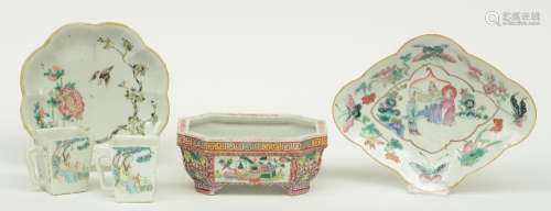 Two Chinese famille rose plates and a jardinière, decorated with flower branches, figures and antiquities, two marked; added two polychrome quadrangular tea mugs decorated with a woman and a child, marked, W 29 - D 23 - Diameter 22,5 cm (one plate and on cup with chip on the rim)