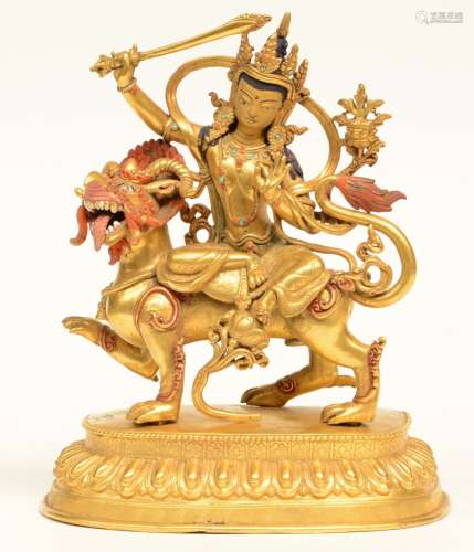 A fine Tibetan gilt bronze Boddhisatva seated on a mythical animal, polychrome decorated with turquoise and red coral pearls, late 18thC, H 29 - Diameter 24 cm