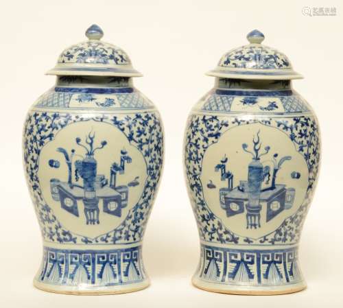 A pair of 19thC Chinese blue and white vases and covers, painted with floral motifs, the roundels decorated with antique objects, H 49 cm (chips)