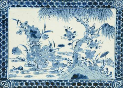 An 18thC blue and white decorated Chinese tile, the central part painted with a willow tree and flowers, the rim frieze with honeycombs and ruyi, 23 x 31,5 cm