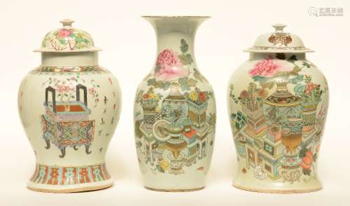 Two Chinese famille rose vases and covers, decorated with vas of flowers and antiquities; added a dito vase, H 42,5 - 44,5 cm (chips on the rim)