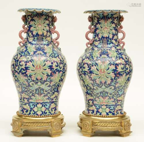A pair of Chinese polychrome vases, relief moulded with dragons, symbols and floral motifs, with gilt bronze mounts, H 49,5 cm (one vase with cracks on the body and restored)