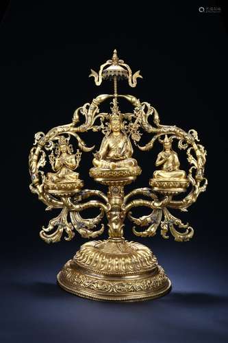 A gilt-bronze Padmasambhava and two gurus on stand