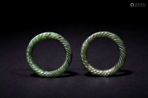 A pair of small green jade bangles