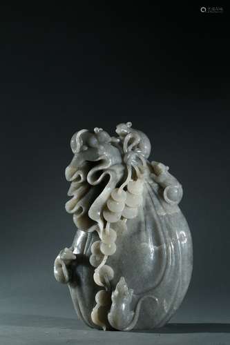 A grey jade carving of coin bag