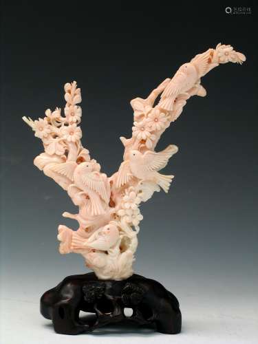 Chinese pink coral carving on wood stand.