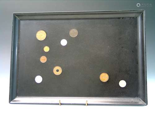 A lacquer tray with international coins inlaid.