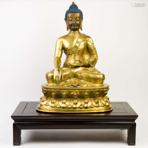 A GILT-BRONZE FIGURE OF BUDDHA WITH RED WOODEN BASE