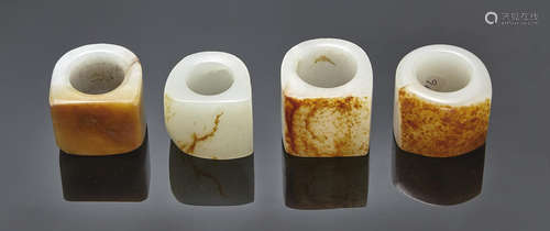 A group of four russet and white jade archer's rings Qing dynasty