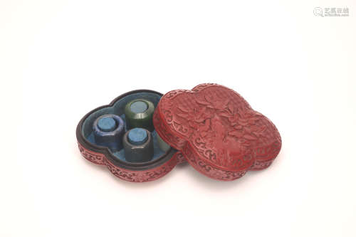 Four Chinese Jade Rings in a Lacquer Ring Holder with Cover