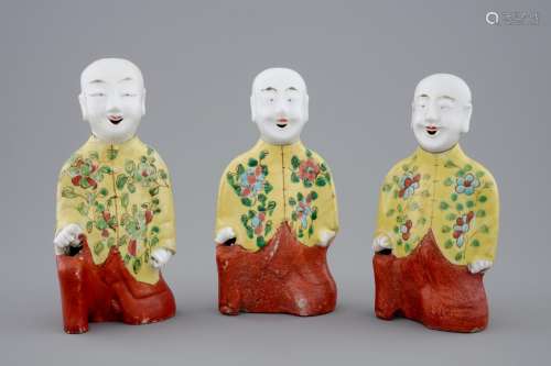 A set of three Chinese porcelain figures of kneeling boys, 19th C.