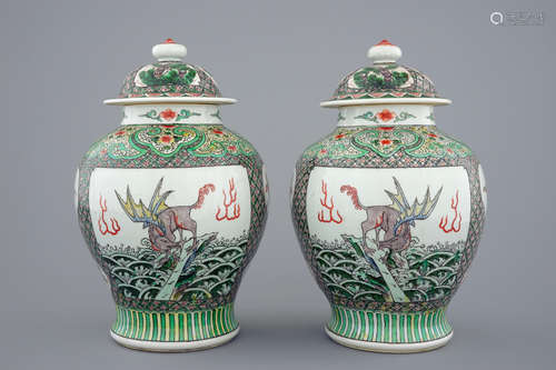 A pair of Chinese famille verte vases and covers with mythical beasts, 19/20th C.