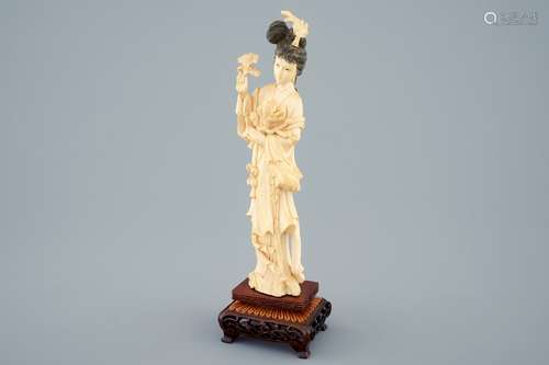 A Chinese carved ivory figure of a beauty with flowers on wooden base, early 20th C.