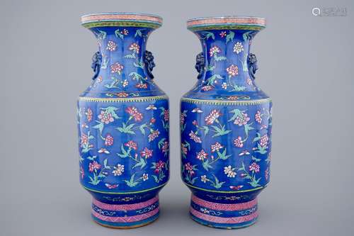 A pair of Chinese blue ground famille rose vases with flowers, 19th C.