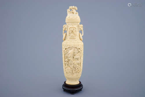 A Chinese carved ivory vase and cover on a wooden base, early 20th C.