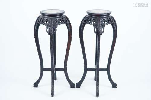 A pair of tall round Chinese carved wood stands with marble top, 19/20th C.