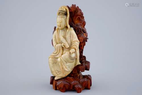 A fine figure of a Guanyin in soapstone on a wooden base, 18/19th C.