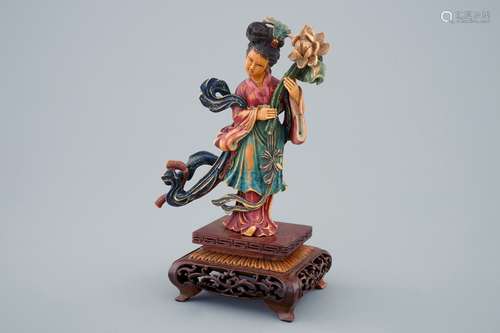 A Chinese polychrome carved ivory figure of a lady with flowers on wooden base, early 20th C.