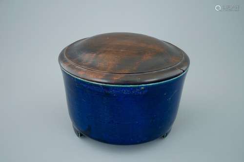 A Chinese monochrome blue cylincrical tripod incense burner with wood lid, 19th C.