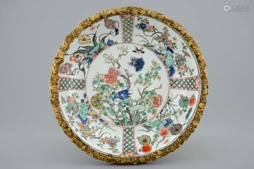 A Chinese famille verte plate with a gilt bronze mount, Kangxi