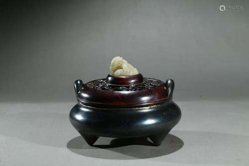 A bronze tripod censer with white jade lion finial cover