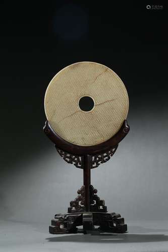 An archaic jade disc with hardwood stand