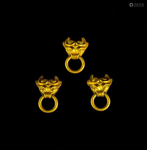 A Set of Three Miniature Gold Mask Form Handles