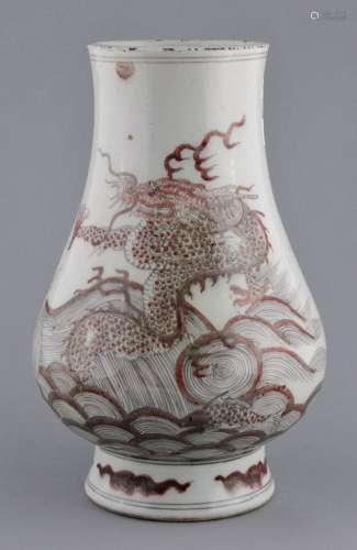 Porcelain vase. China. 19th century. Underglaze red decoration of a dragon and crashing waves. Six character K'ang Hsi mark on the base. Rim fritting. 11