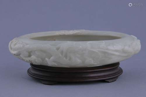 Jade bowl. China. 20th century. Pale celadon white colored stone. Oval shape. Surface and interior carved with dragons. 9