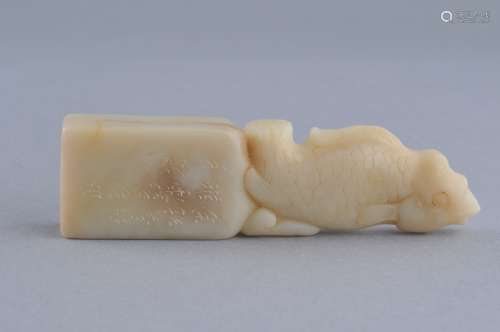 Soapstone seal. China. 19th century. Ivory coloured stone. Finial in the form of a dragon carp. Inscription on one side. Seal intact. 4