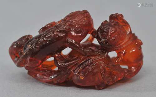 Amber carving. China. 19th century. Study of two foo dogs with a brocade ball. 2-1/4