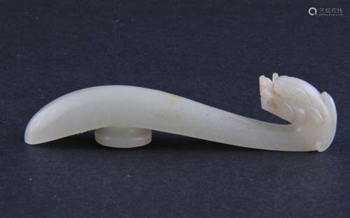 Jade garment hook. China. 19th century. Pale green-white stone. Finial carved as a dragons head. 3-3/4