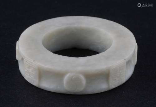 Jade ring. China. 19th century. White stone with black markings. Decoration of square projections with a Ch'ien Lung inscription. 1-3/4