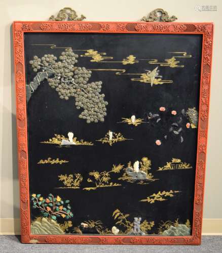 Inlaid plaque. China. Early 20th century with older elements. Carved Cinnabar frame with repousse bronze hangers. Panel of black and gold lacquer inset with figures of The Immortals in a garden in jade, rose quartz, coral and malachite. 47