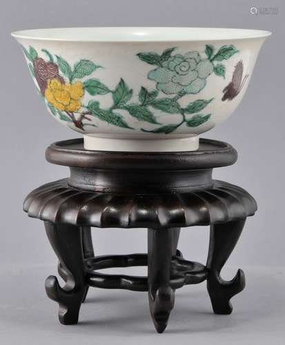 Porcelain bowl. 19th century. San Tsai decoration of flowers and butterflies on a ground engraved with An Hua dragons. K'ang Hsi mark. Hairline and abrasion to the interior.  6