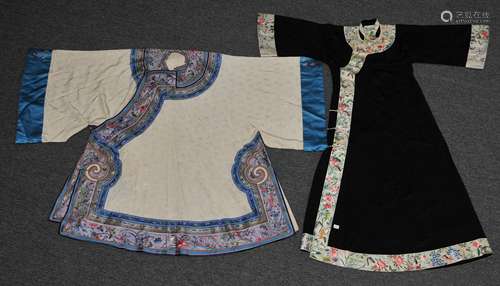 Lot of two robes. China. 19th century to early 20th century. A white brocade robe with purple borders embroidered with birds, butterflies and flowers together with a black brocade robe with white borders embroidered with goldfish, butterflies and lotus.