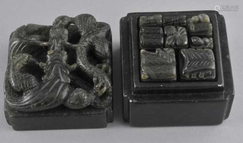 Soapstone box containing nine seals. China. 20th century. Dark green stone with a dragon on the cover. Seals with a floral finials. 2-1/2