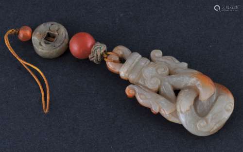 Jade pendant. China. 19th century. Grey stone with russet areas. Carved as a pair of confronting dragons. 2-1/2
