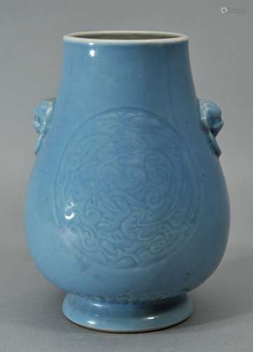 Porcelain vase. China. 19th cent. Pear shaped with foo dog handles. Body engraved with reserves of carved dragons and phoenixes. Pale blue monochrome glaze. Yung Cheng mark. 6-3/4