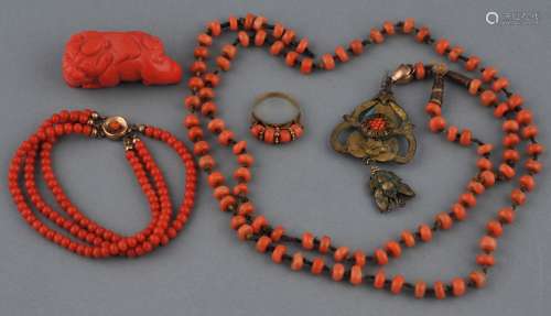 Lot of coral to include: A foo dog, two necklaces and a ring.