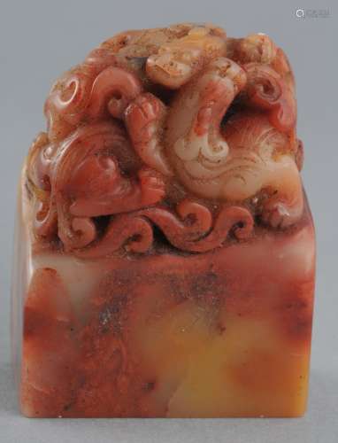 Soapstone seal. China. 19th century. Chicken blood stone. Finial in the form of swirling mythical animals. 2-1/2