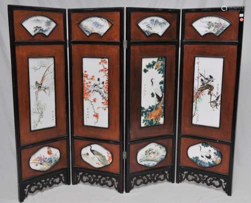Four panel screen. China. Mid 20th century. Porcelain panels of birds and flowers. Carved wooden frame. 29