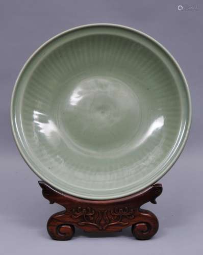 Large Celadon charger. China. Yuan period (1279-1368). Lung Chuan ware. Carved decoration of a floral reserve with ribbed borders. Heavily potted.  19