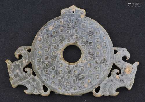 Jade Archaic Ritual Disk. China. Chou style. Green stone with considerable calcification. Pi disk with a pair of phoenixes. Surface covered with comma marks. 3-3/4